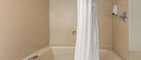 A bathroom with a bathtub, a shower curtain, and a towel rack.