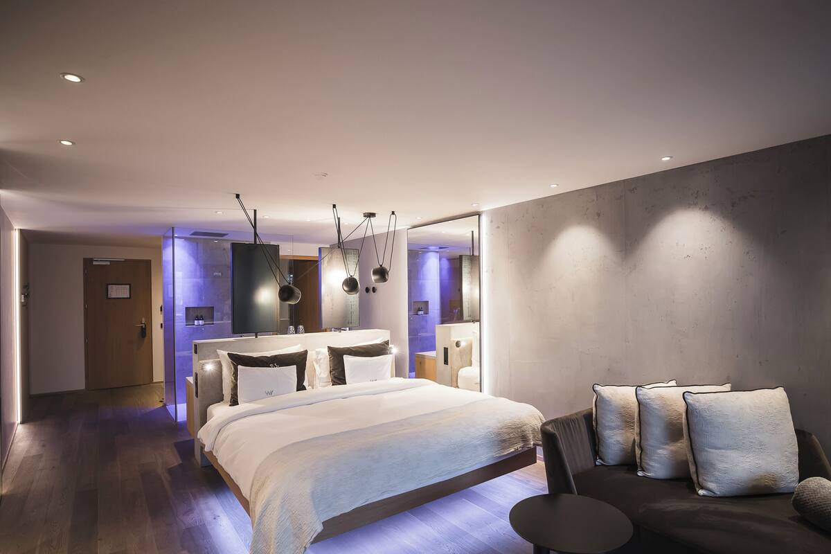 Une chambre d’hôtel moderne, dotée d’un grand lit, d’un canapé et d’un espace bureau.