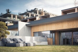 A modern building with a flat roof, large windows, and a wooden facade. - Hotel Winkler (San Lorenzo di Sebato)