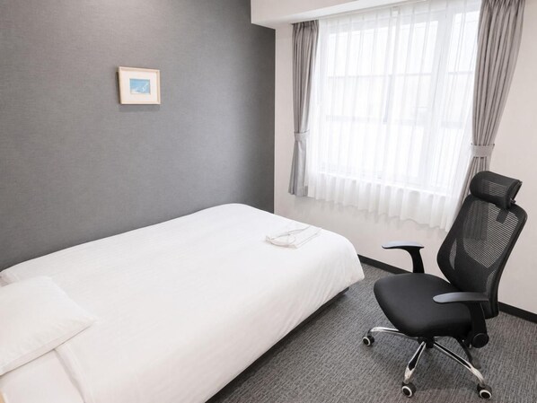 A hotel room with a single bed, a chair, a window with curtains, and a framed picture on the wall. - Hotel Shin Osaka (Osaka)