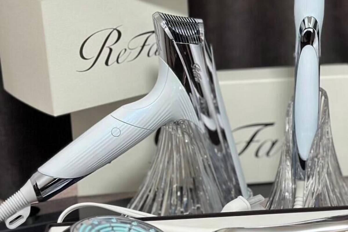 A set of grooming tools including a hair clipper, a straightener, and a comb, all placed in a white box labeled 'ReFa'.