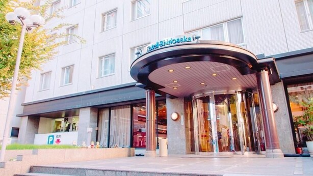 A hotel entrance with a curved glass facade, a visible parking sign, and a staircase leading to the entrance. - Hotel Shin Osaka (Osaka)