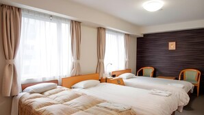 A hotel room with two beds, a wooden headboard, a bedside table with a lamp, and a dark wood accent wall. - Hotel Shin Osaka (Osaka)