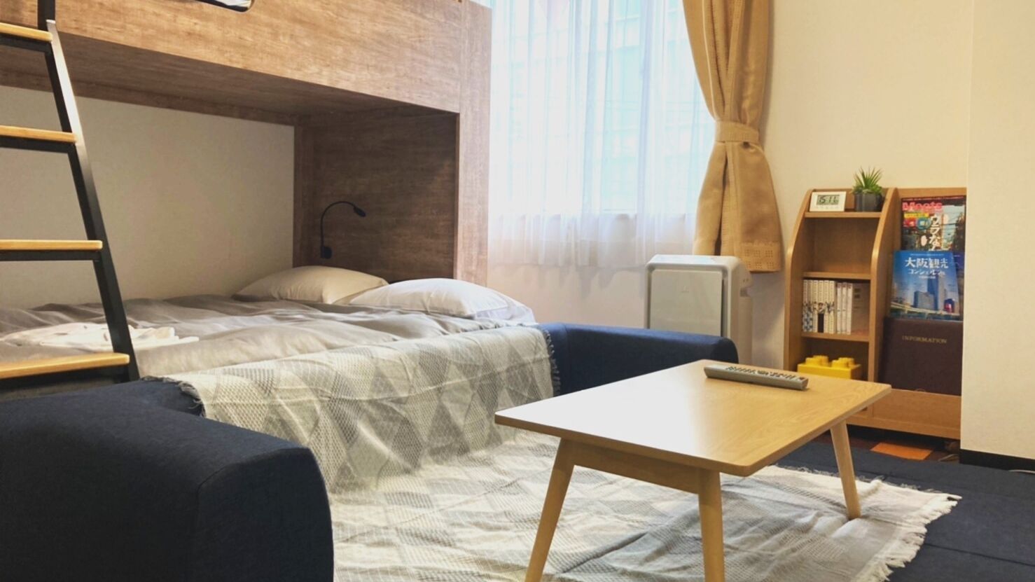 A bunk bed with a desk and chair, a bookshelf, and a window with curtains.