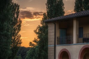 Un edificio con balcón, ventanas de arco y fachada de piedra.