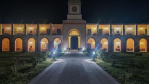 A hotel with a central arched entrance, multiple balconies, and a clock tower. - Casale La Sterpaia (San Giuliano Terme)