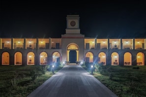 A hotel with a central arched entrance, multiple balconies, and a clock tower. - Casale La Sterpaia (San Giuliano Terme)