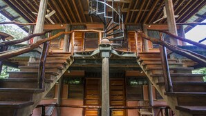 A wooden staircase leading to a wooden deck with a bench and a chair. - Cotton Tree Lodge (Punta Gorda)