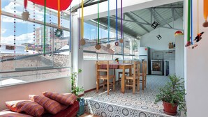 A bright, open-plan living space with a dining area, large windows, and a view of the cityscape. - Magic Cusco (Cusco)