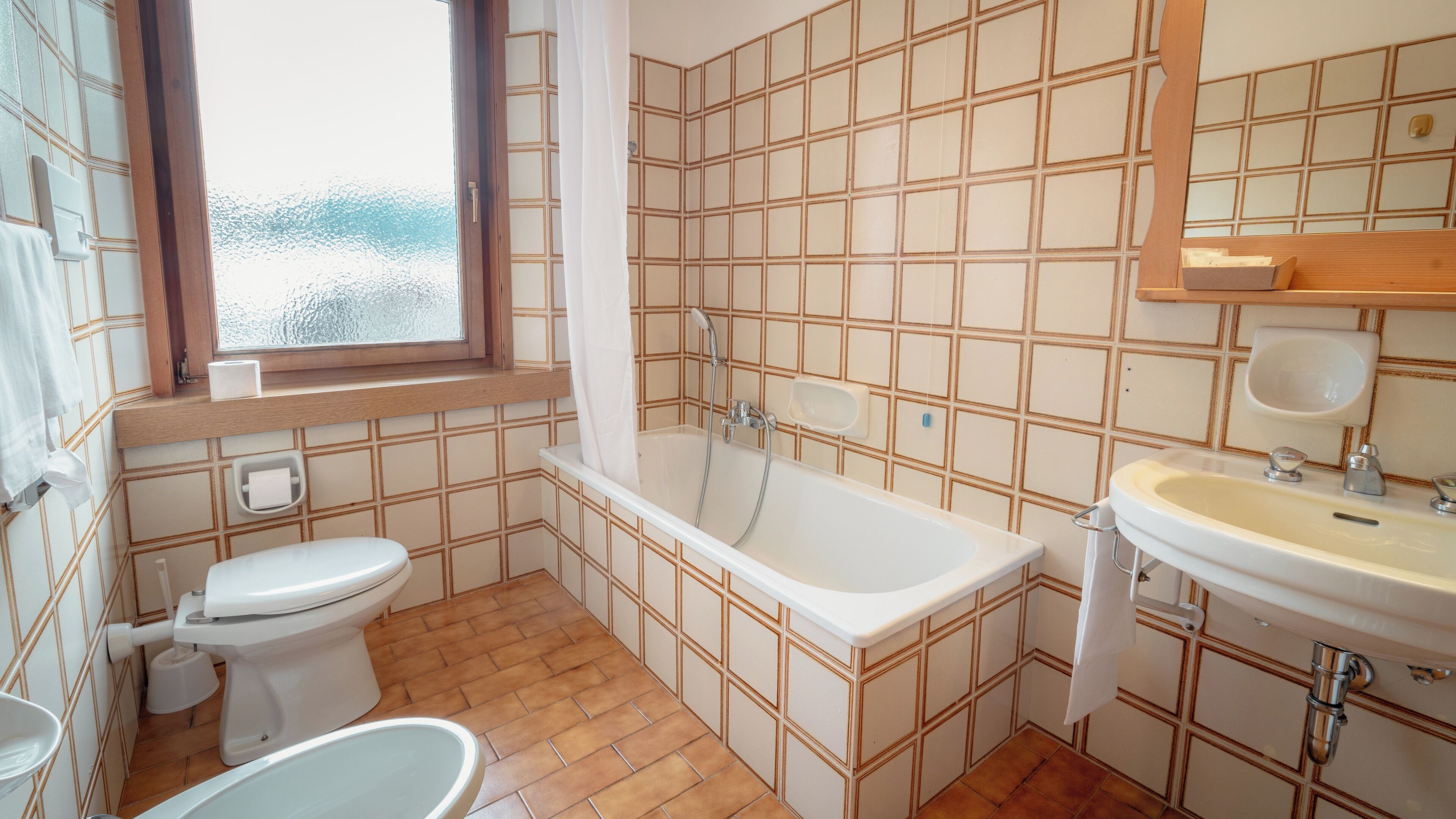 A bathroom with a bathtub, toilet, and sink.