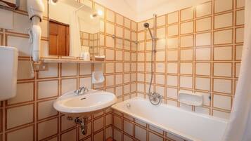 Un baño con lavabo, bañera, ducha y espejo.