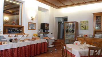 Un comedor con una disposición tipo bufé, una cocina al fondo y una mesa con sillas.