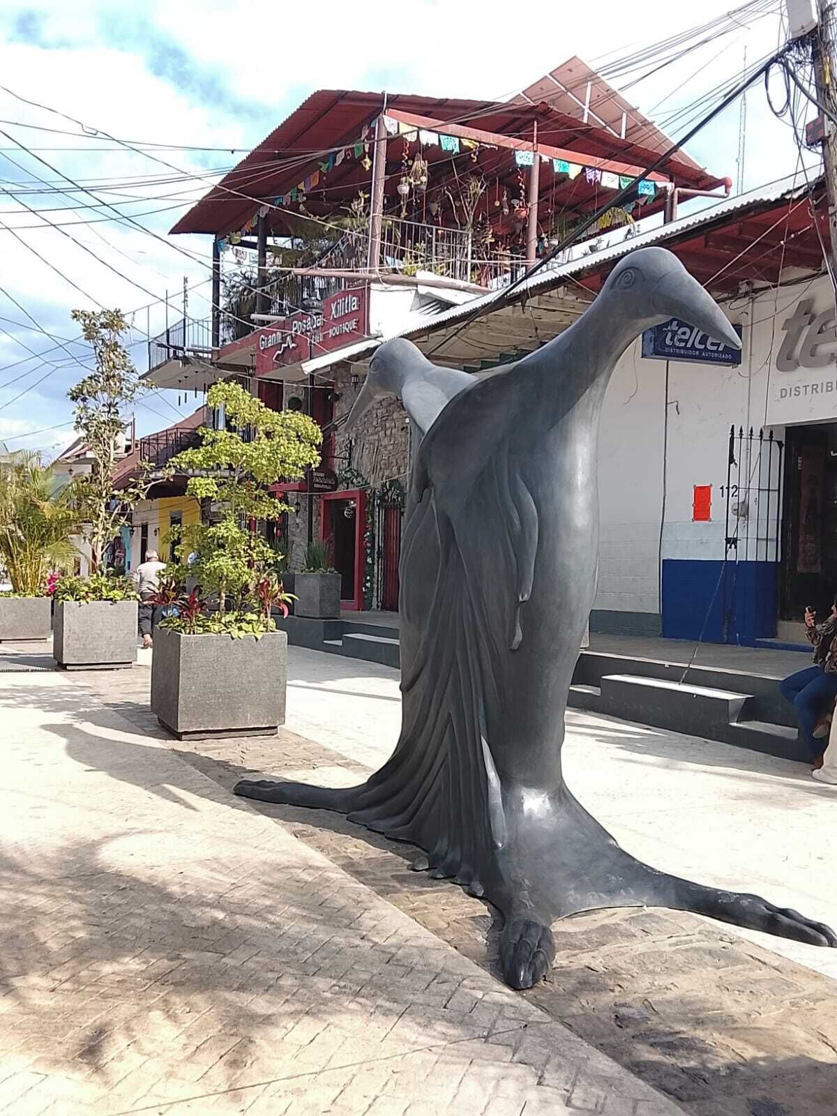 Un'ampia scultura esterna raffigura una figura con un abito svolazzante.