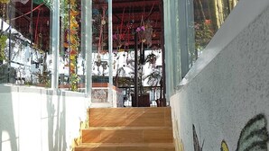 A staircase leading to a covered area with hanging decorations and a view of the outside. - Grann Posada Xilitla (Xilitla)