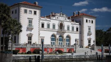 A large, white building with a red-tiled roof, multiple windows, and a grand entrance.