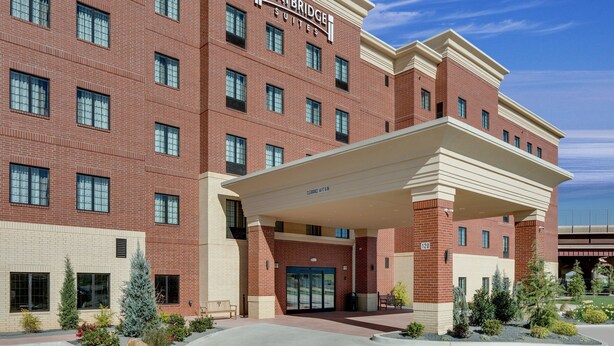 A Staybridge Suites hotel with a brick facade, multiple windows, and a covered entrance.
