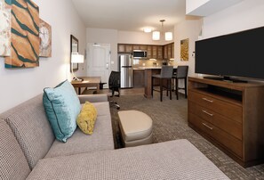 A compact living space with a kitchenette, a dining area, and a seating area with a sofa and ottoman. - Staybridge Suites Oklahoma City Dwtn - Bricktown by IHG (Oklahoma City)