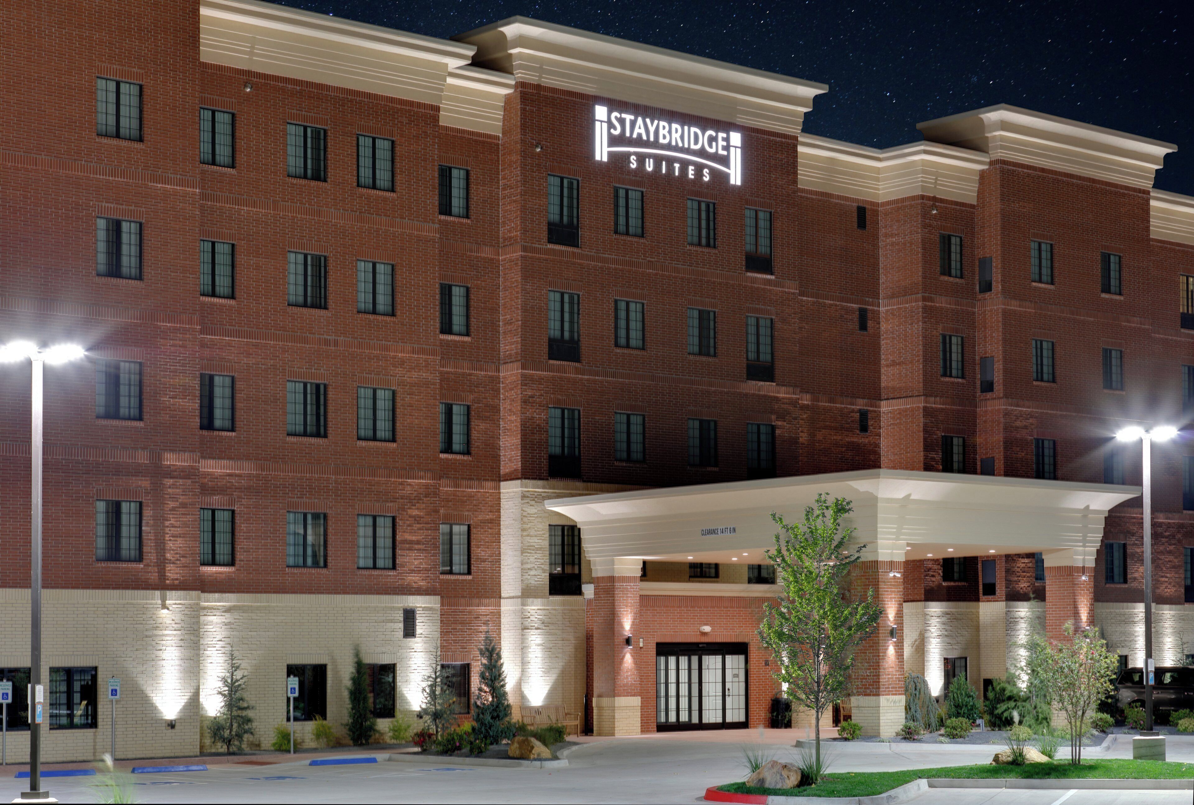 Un hotel Staybridge Suites con fachada de ladrillo, varias ventanas y un acceso cubierto.