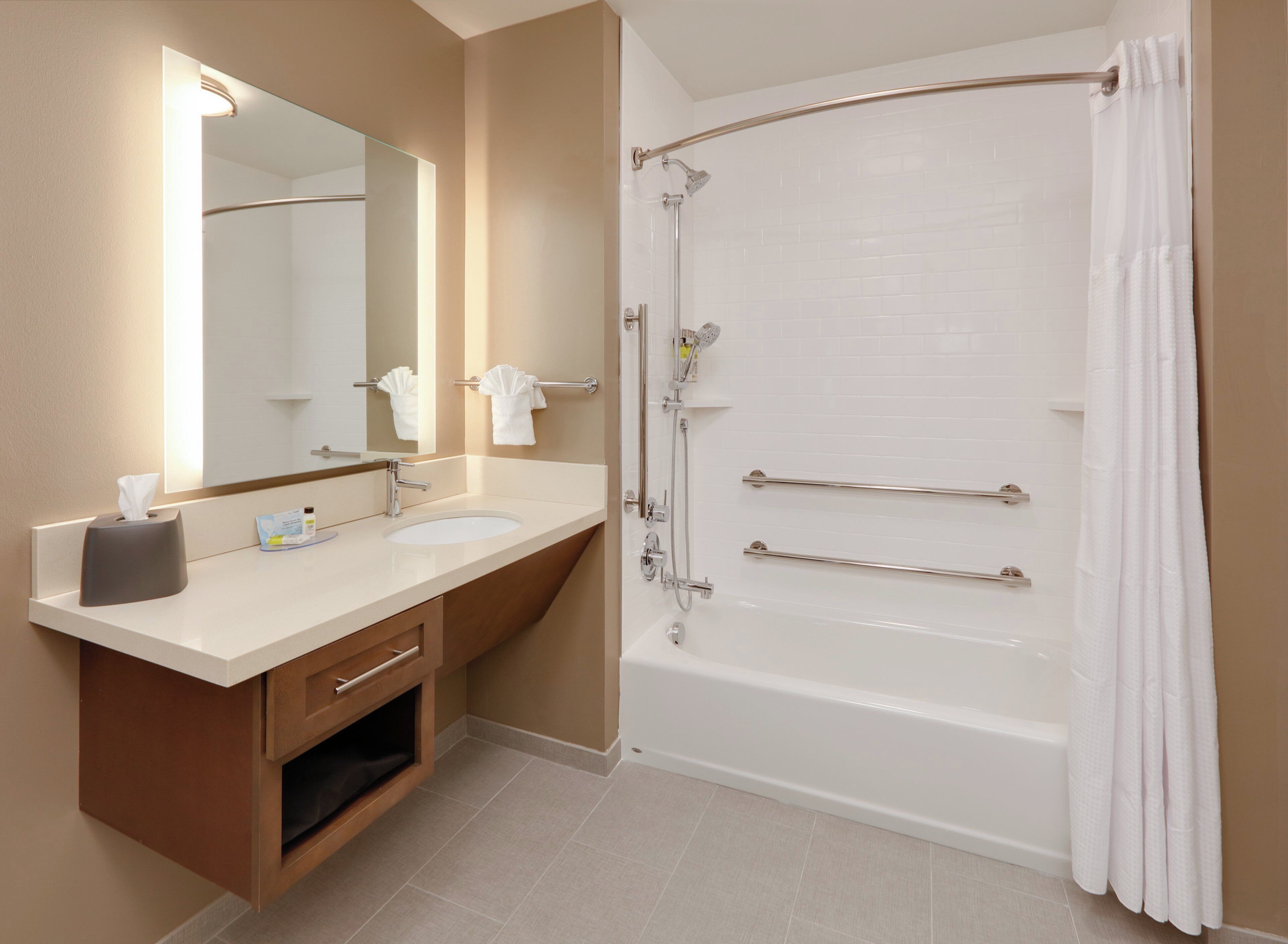 A modern bathroom with a bathtub, a double sink vanity, a mirror, and a towel rack.