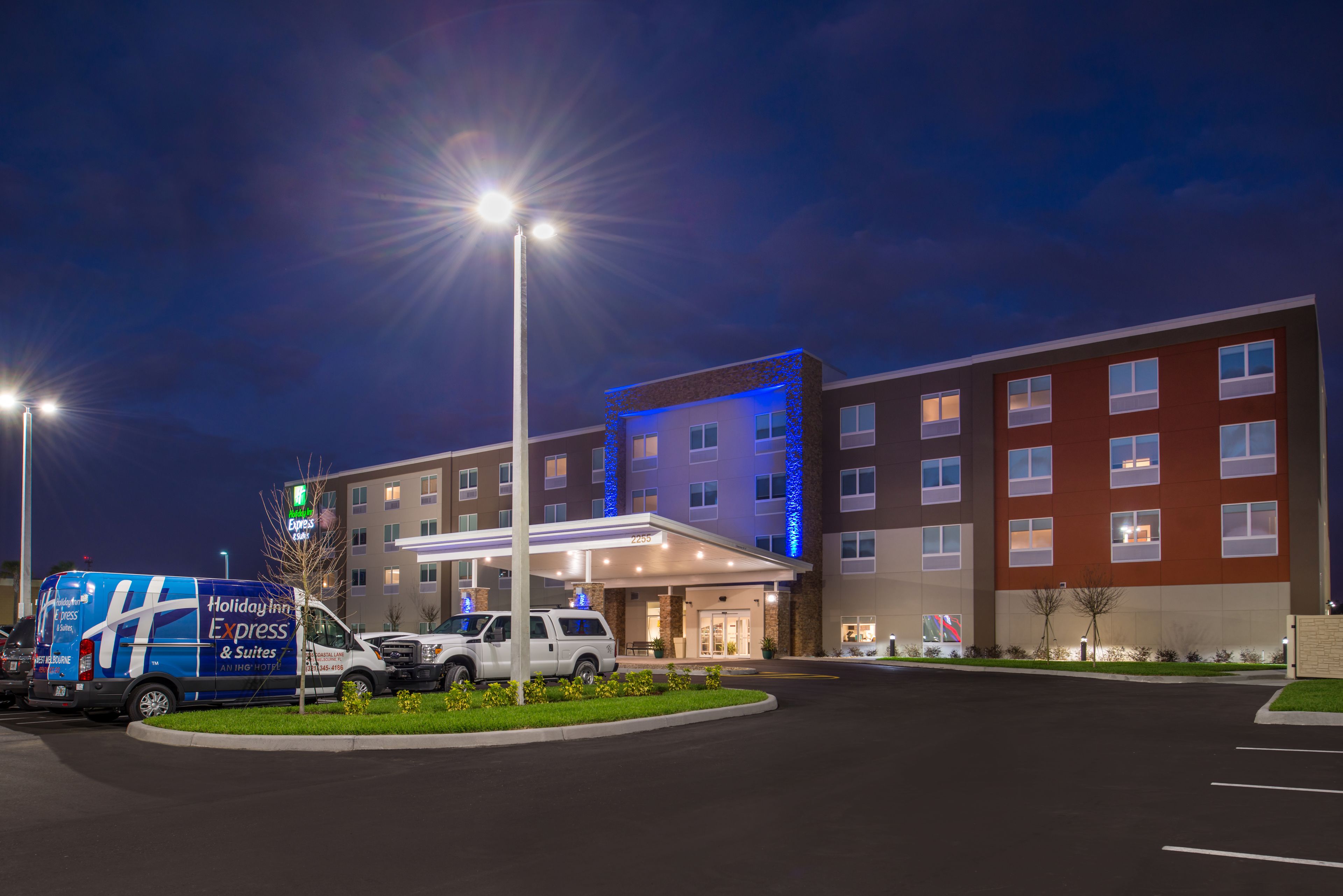 A Holiday Inn Express hotel with a parking lot, a covered entrance, and a building with multiple windows.