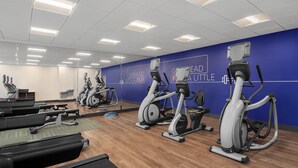 A gym with treadmills, stationary bikes, and elliptical machines.