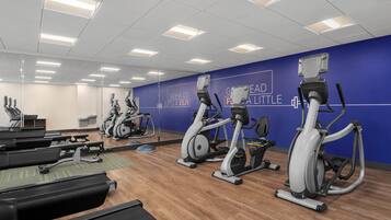 A gym with treadmills, stationary bikes, and elliptical machines.