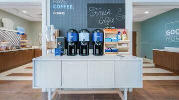 A coffee station with three coffee dispensers, a sign reading "MUST HAVE COFFEE," and a chalkboard with "Fresh Coffee" written on it.