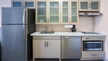 A modern kitchen with stainless steel appliances, including a refrigerator, dishwasher, and microwave.