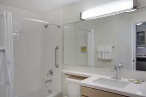 Bathroom features a walk-in shower, sink, and toilet with a towel rack.