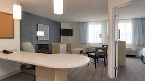 A hotel room with a desk, chair, bed, and a television. - Candlewood Suites Miami Intl Airport - 36th St by IHG (Miami)