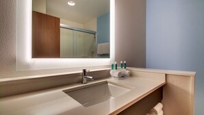 Une salle de bain moderne avec un grand miroir, un lavabo et un porte-serviettes.