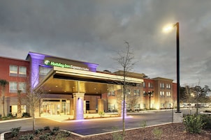 Un Holiday Inn Express & Suites con entrada cubierta y estacionamiento.
