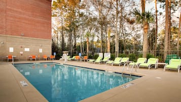 Una piscina al aire libre de temporada, sillones reclinables de piscina