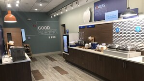 A modern breakfast area with a digital menu display, a coffee machine, and a variety of breakfast items on the counter. - Holiday Inn Express & Suites Summerville by IHG (Summerville)