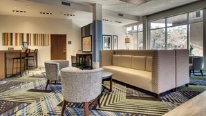 A modern lobby with a seating area, a reception desk, and large windows. - Holiday Inn Express & Suites Summerville by IHG (Summerville)