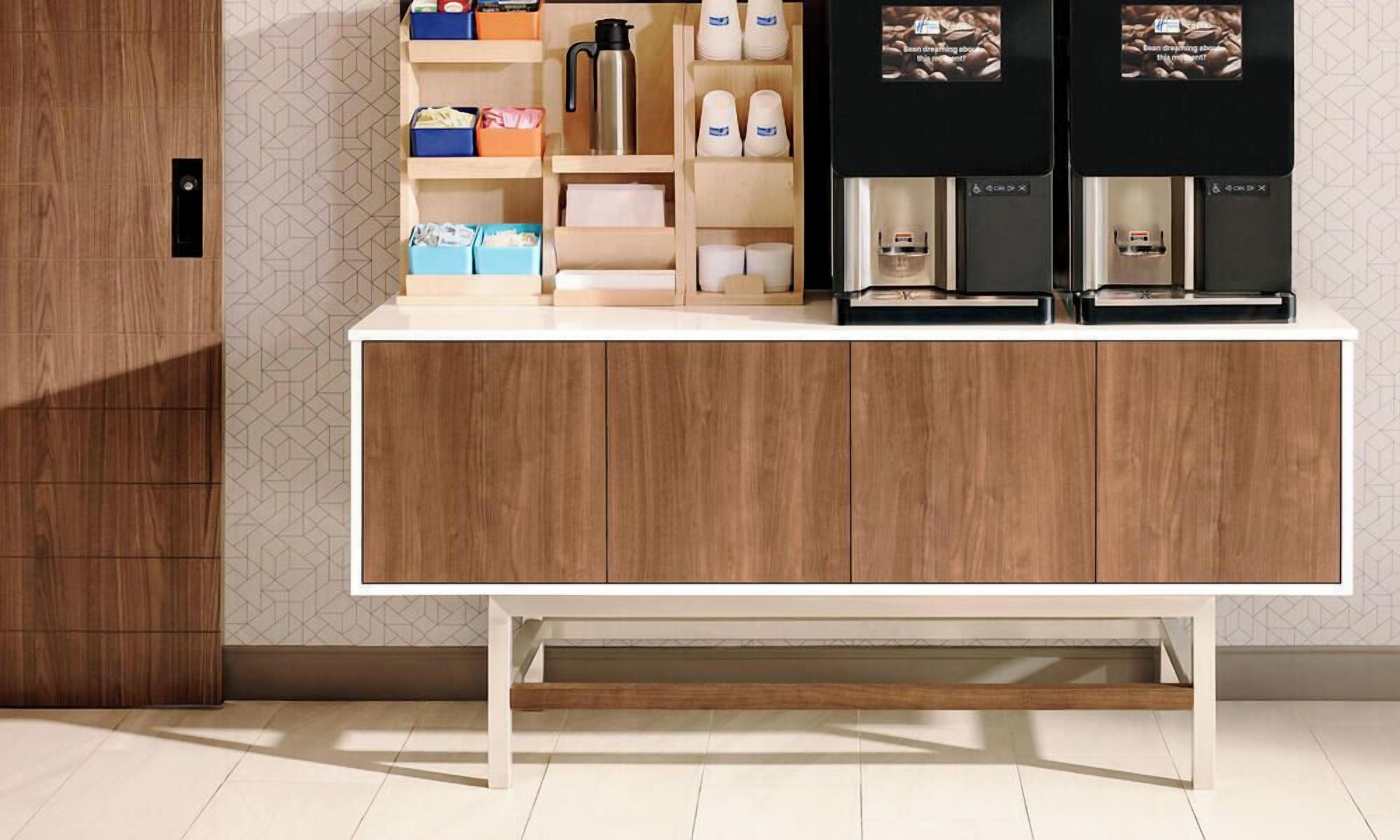 Una cucina moderna con un armadietto in legno, un angolo caffè con macchina da caffè e contenitori portaoggetti.