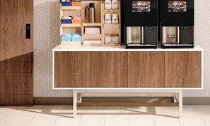 A modern kitchen with a wooden cabinet, a coffee station with a coffee machine, and storage boxes. - Holiday Inn Express Auburn Hills South by IHG (Auburn Hills)