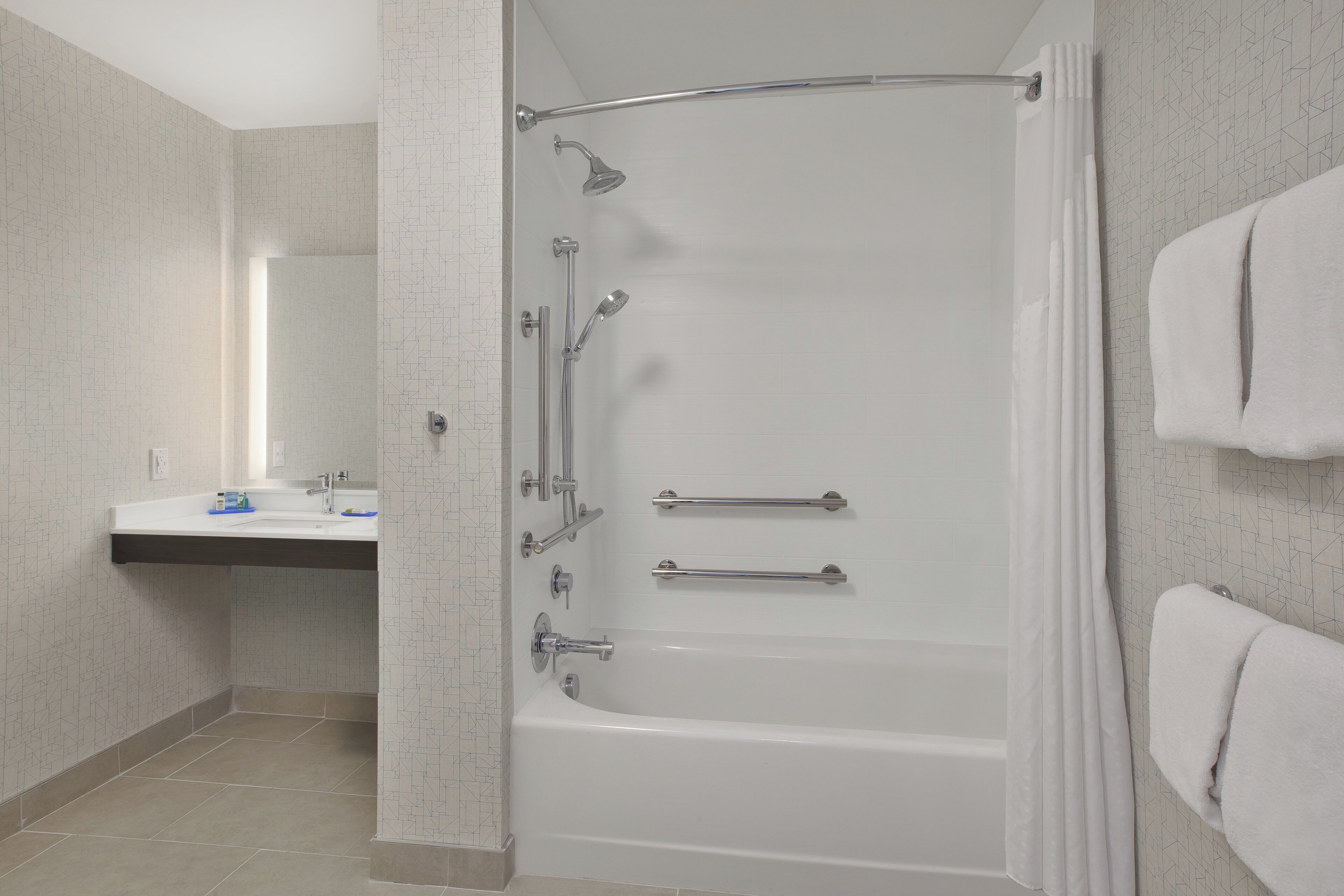 Une salle de bain moderne avec une baignoire, une douche et un meuble-lavabo.