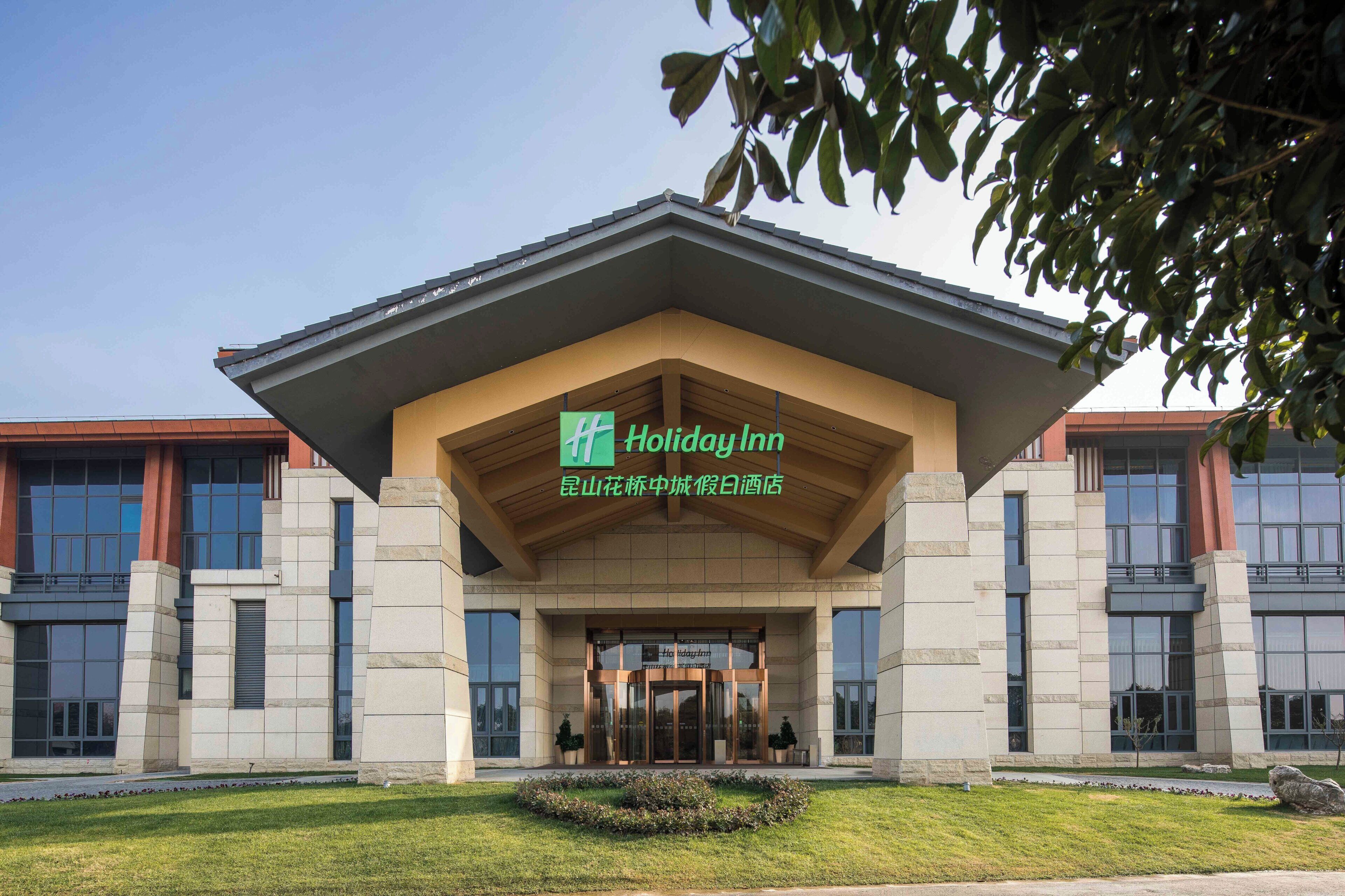 Un hôtel Holiday Inn doté d’une façade moderne, de grandes fenêtres et d’une pelouse bien entretenue.