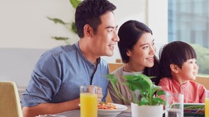 A family dining at a table with plates of food, glasses of juice, and a potted plant. - Holiday Inn Kunshan Huaqiao by IHG (Suzhou)