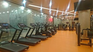 Een sportschool met loopbanden, elliptische trainers en gewichten.
