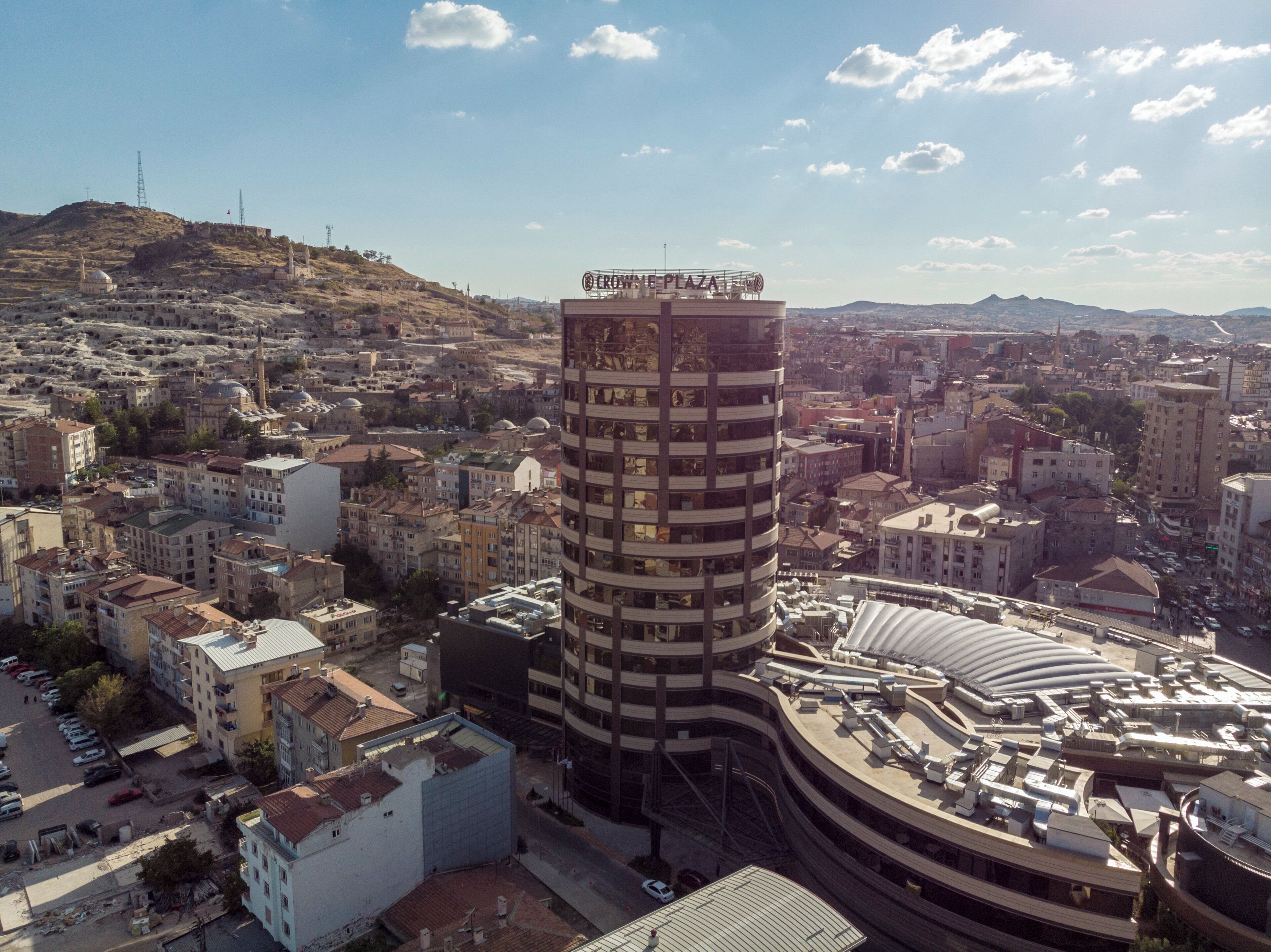 Un edificio de gran altura con un letrero llamativo que dice "CROWN PLAZA" en la parte superior.