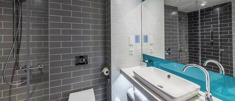 Un baño moderno con ducha, inodoro y lavamanos.