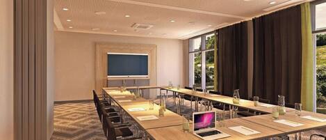 Une salle de conférence équipée d’une longue table, de chaises, d’un écran de projection et d’un ordinateur portable.