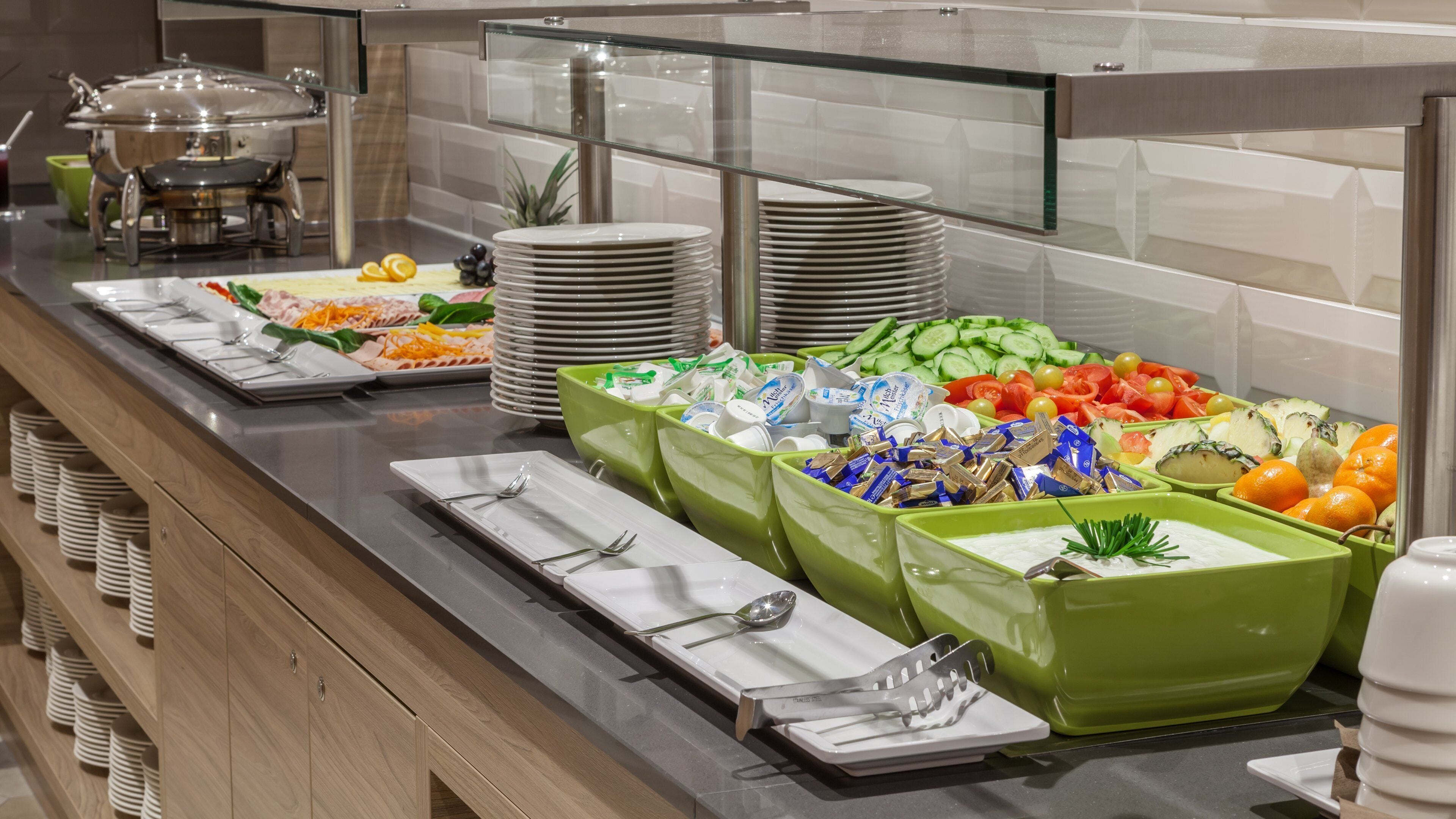 A buffet setup with various food items and utensils.