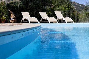 Piscine extérieure en saison, chaises longues