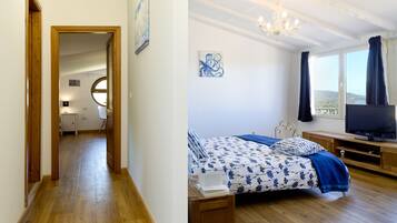 Une chambre à coucher avec un lit, une télévision et une vue sur l’extérieur.