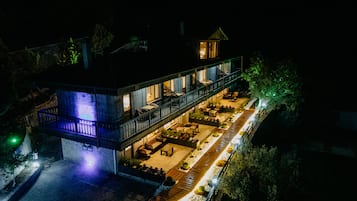Ein Hotel mit Balkon und Sitzgelegenheit im Freien, umgeben von Bäumen.