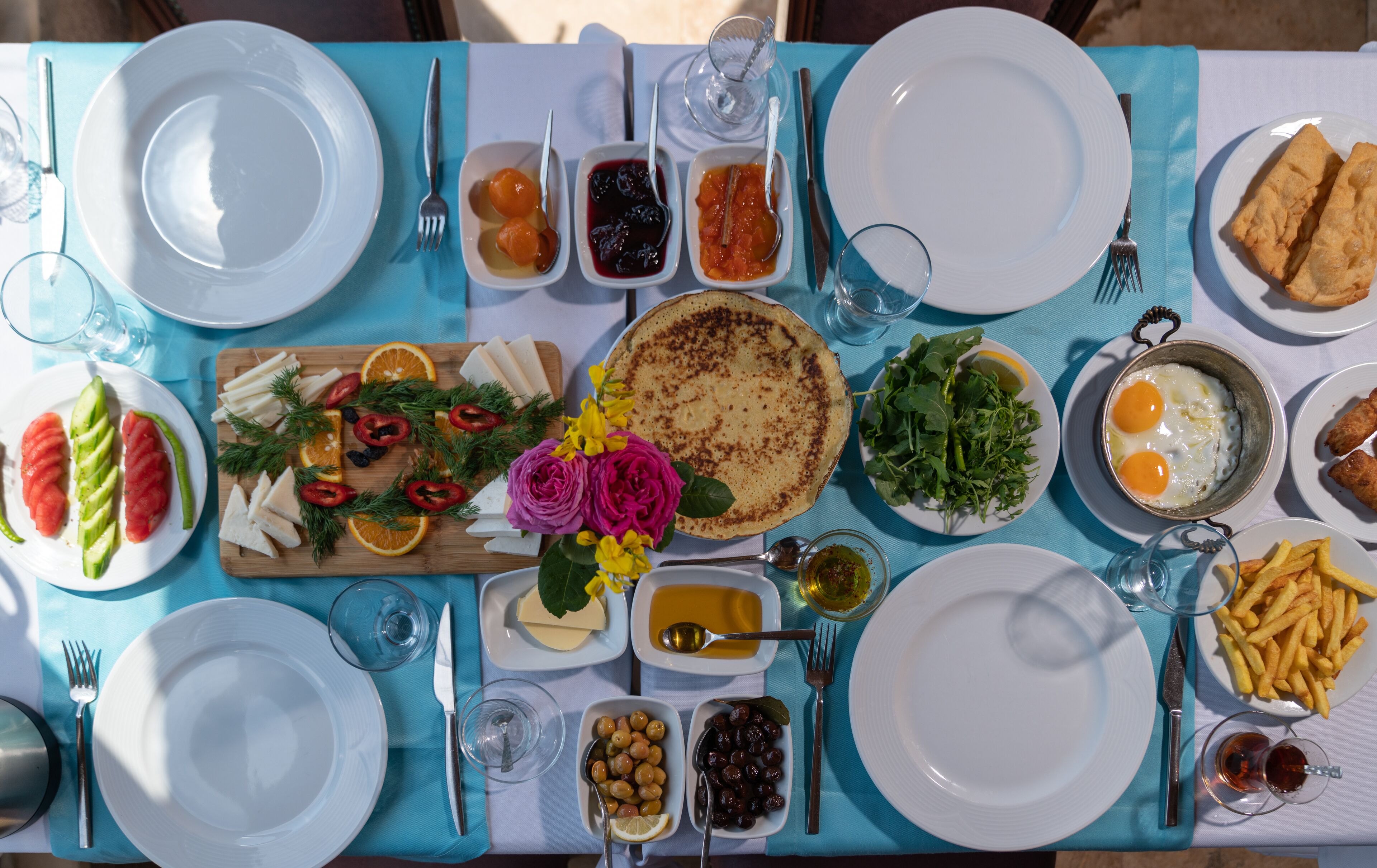A table set for breakfast with various dishes, including eggs, toast, and fruit.