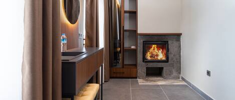 Un baño moderno con tocador, espejo y chimenea.